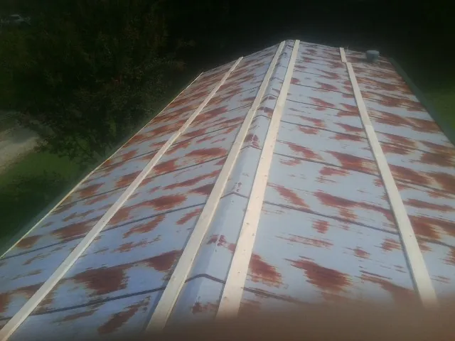 Rusted metal roof panels with new wood purlins before replacement — Storm Damage Roof Repair in Glenfield by Roofing Brothers